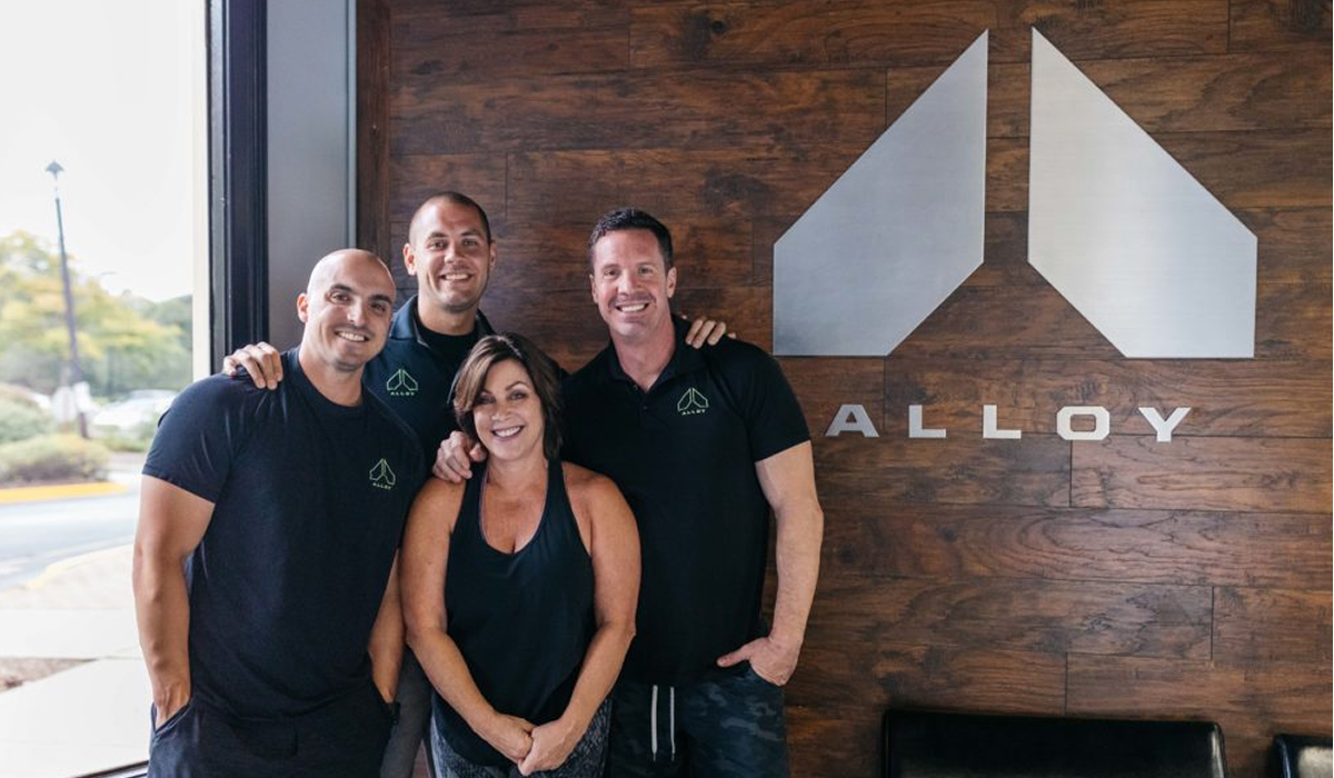 Alloy employees in front of their logo at their entrance