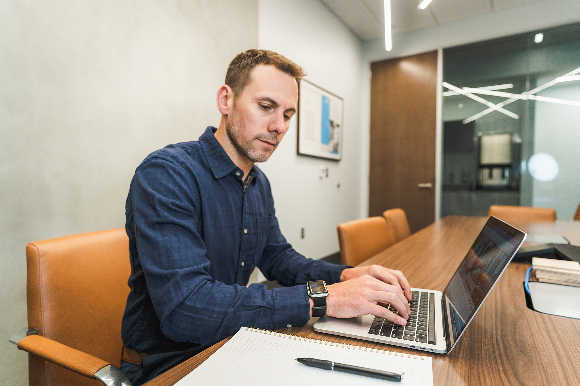 A guy sitting at a table on his laptop